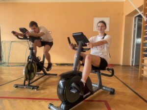 uczniowie ćwiczą na rowerach stacjonarnych