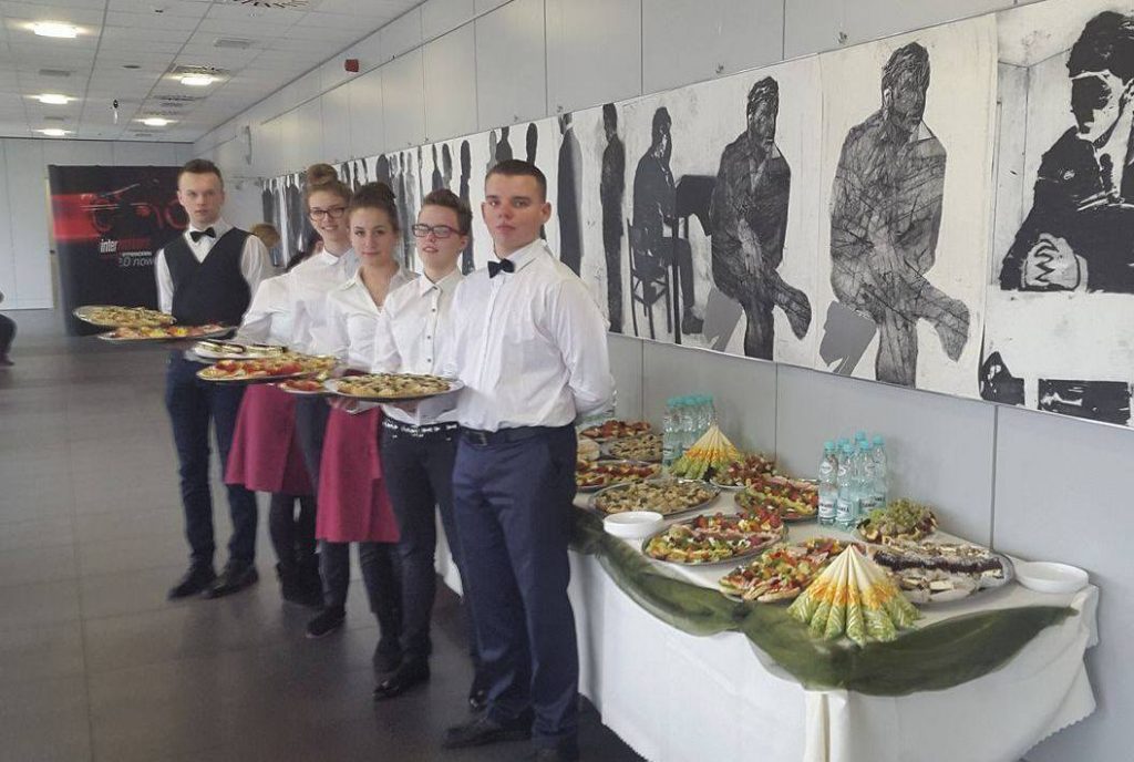 Uczniowie trzymający tace kelnerskie