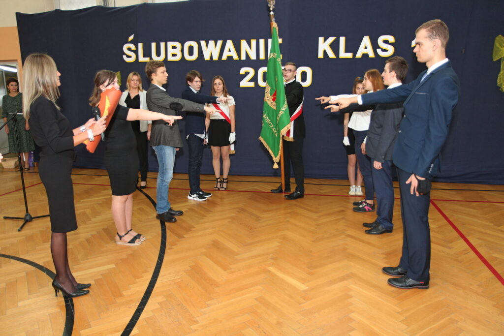 uczniowie stoją i ślubują na sztandar szkoły